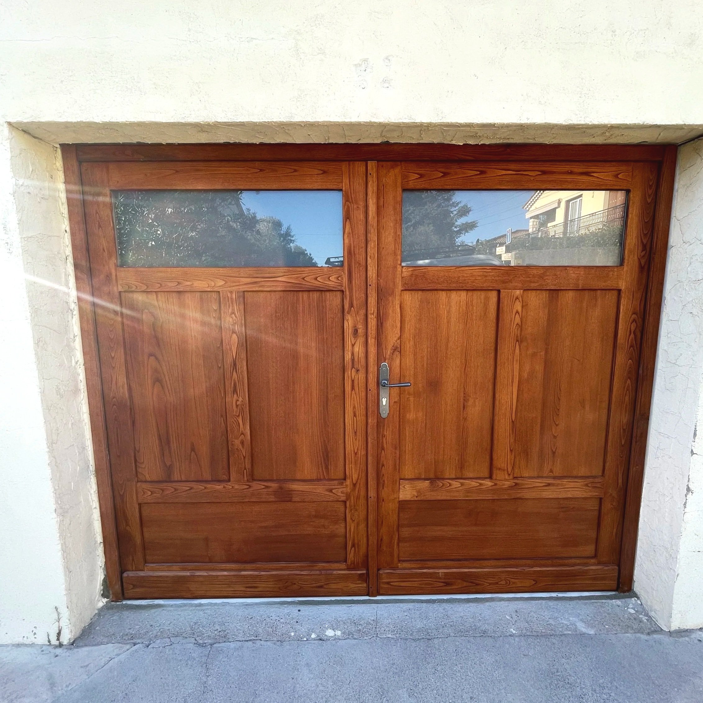 Porte de garage traditionnelle en bois massif réalisée sur mesure.