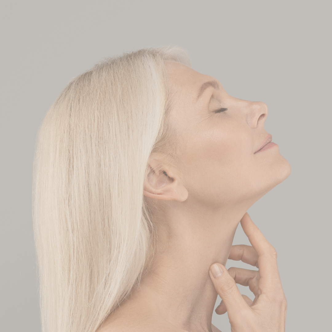 Woman with blonde hair looking up and smiling with her hand on her neck after a botox in harrogate