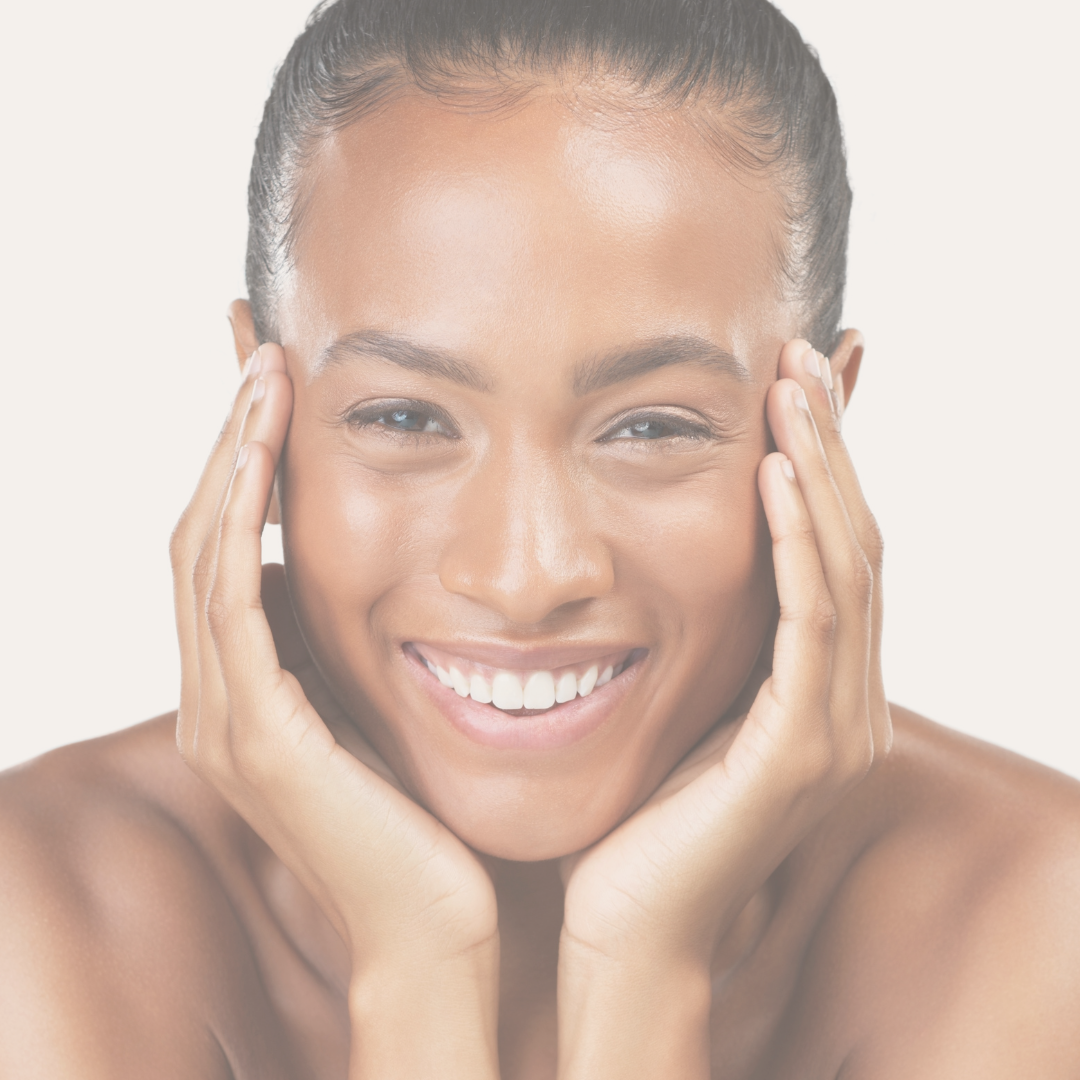Close-up of a smiling woman with hands on her cheeks, looking directly at the camera.