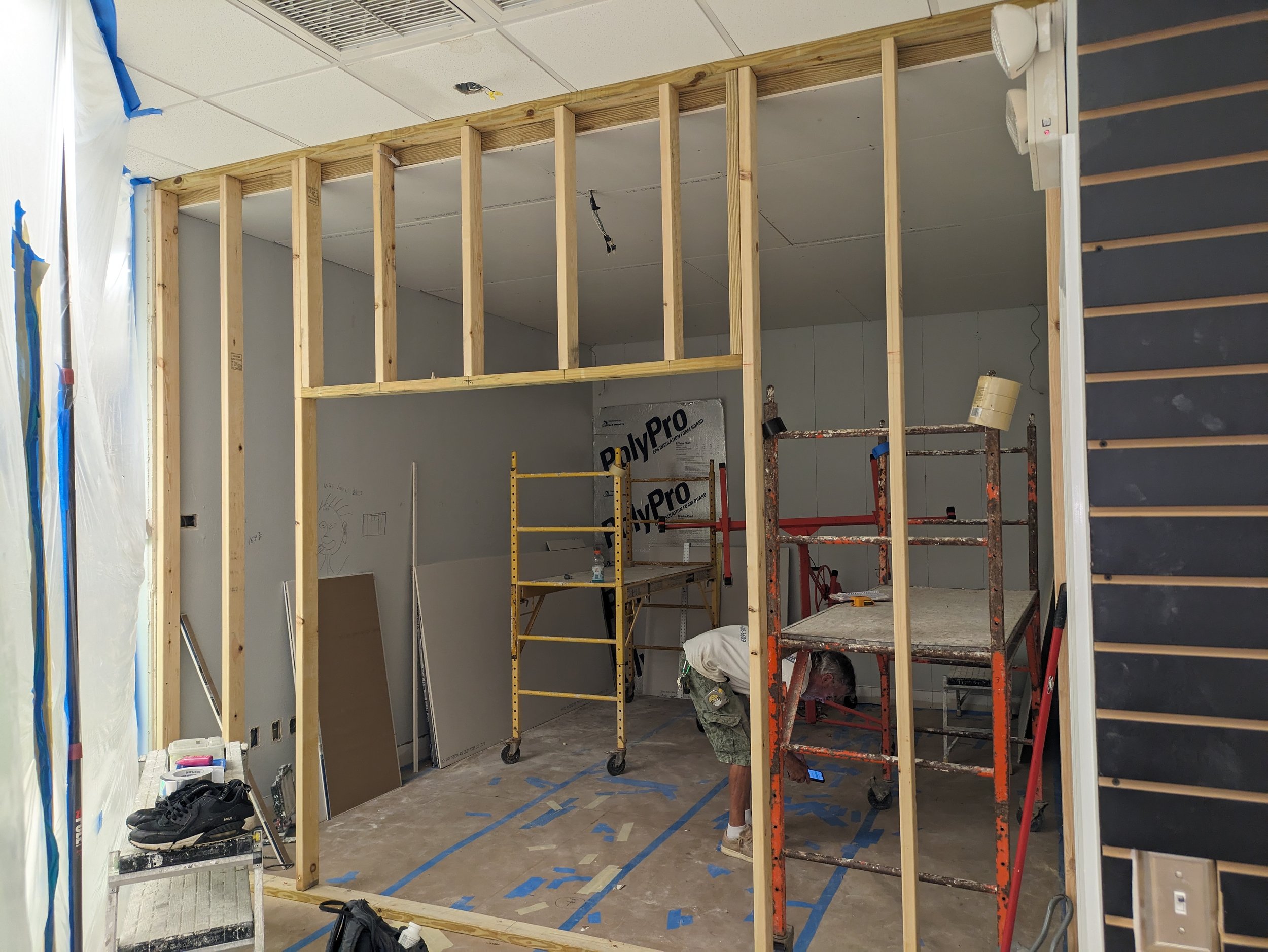 Construction worker installing wooden framing in an indoor renovation project.