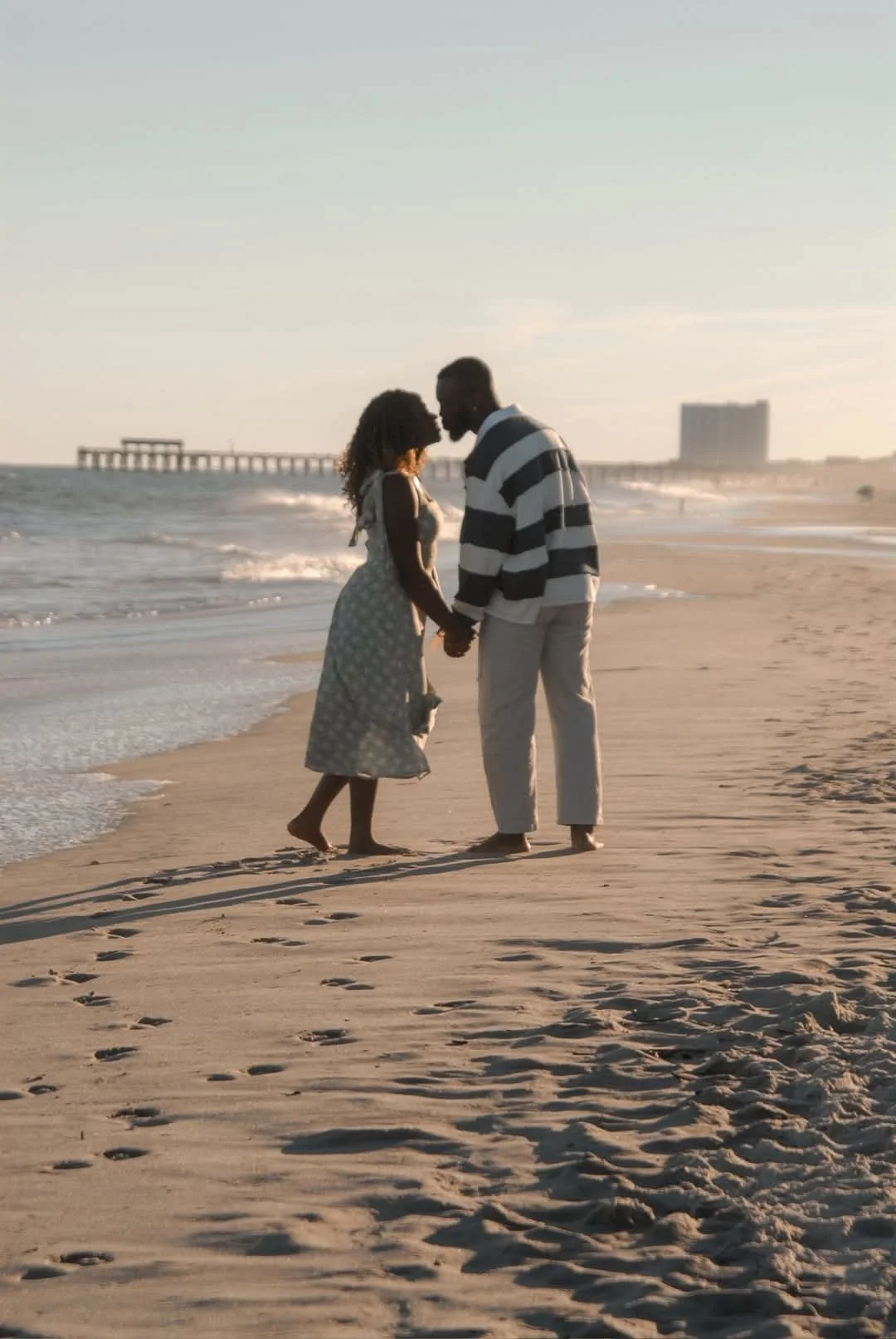 Beach couples photography session at Myrtle Beach, SC, photographed by Faith K Photography with ocean waves and pier in the background.