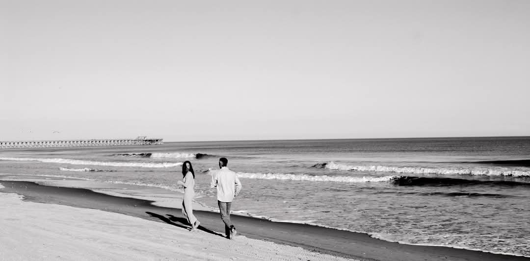 “Coastal couples portrait in Myrtle Beach SC by Faith K Photography capturing romantic walk beside Atlantic Ocean.”