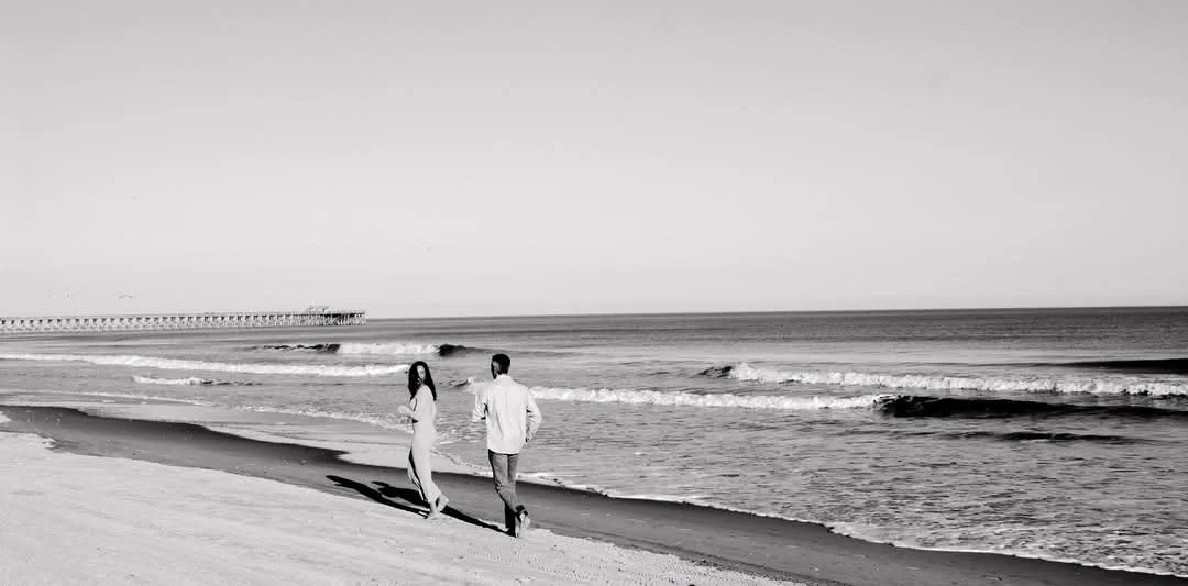 “Coastal couples portrait in Myrtle Beach SC by Faith K Photography capturing romantic walk beside Atlantic Ocean.”