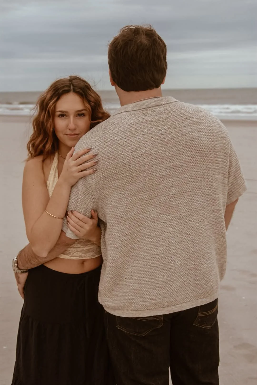 “Engagement session by Faith K Photography in Myrtle Beach SC showing couple embracing on sandy shoreline during coastal sunset.”