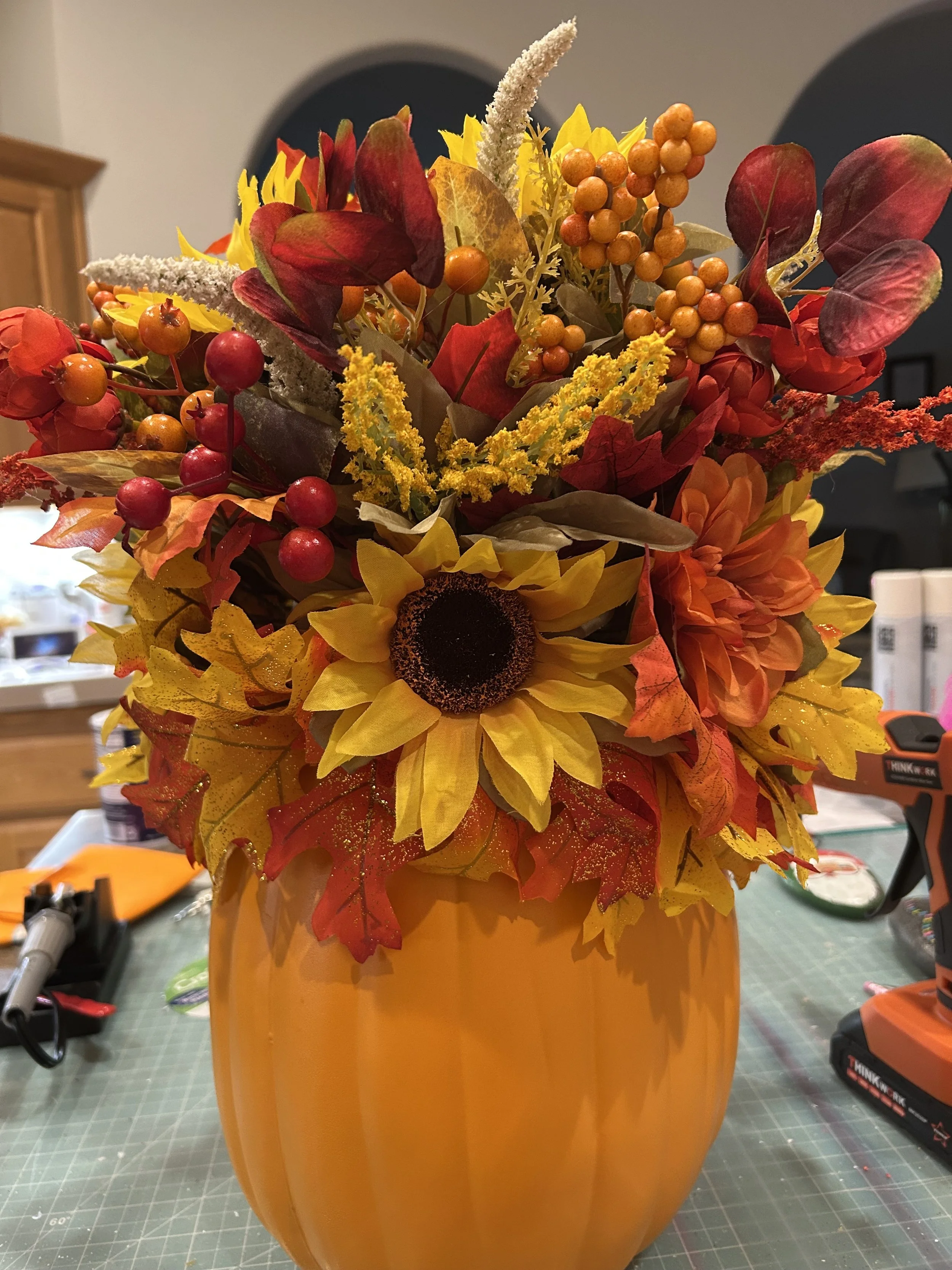 Fall celebration centerpiece pumpkineith yellow sunflowers