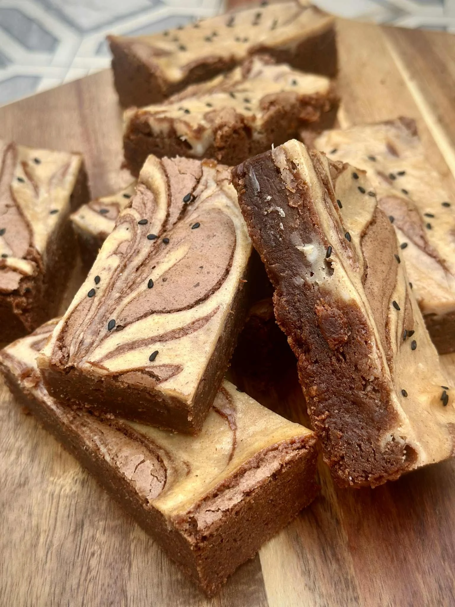 Marble fudge with black sesame seeds on a wooden surface.