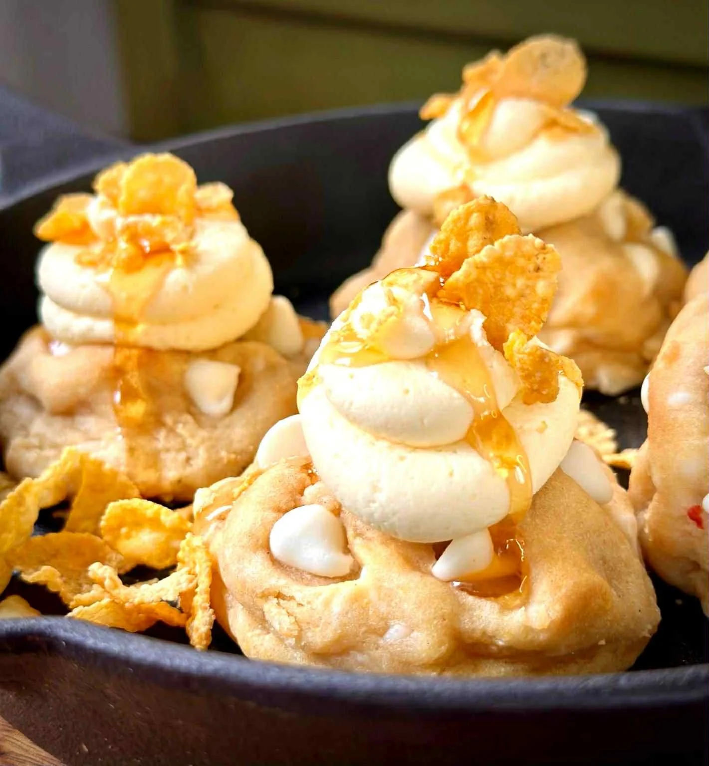 Haitian fried plantains topped with whipped cream, caramel sauce, and cornflakes in a black bowl.