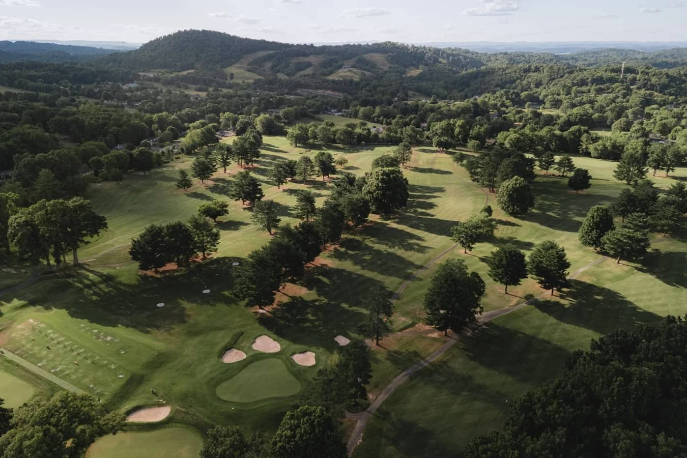 Johnson City Country Club aerial view with fairways, bunkers, and scattered trees, surrounded by rolling hills.