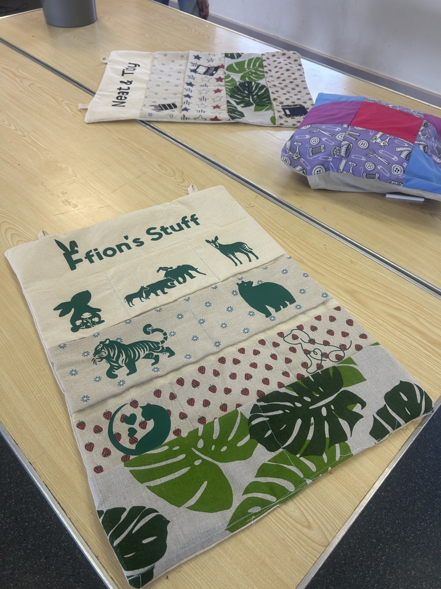 Colorful decorative towels with animal and nature designs, laid out on a light wood table.