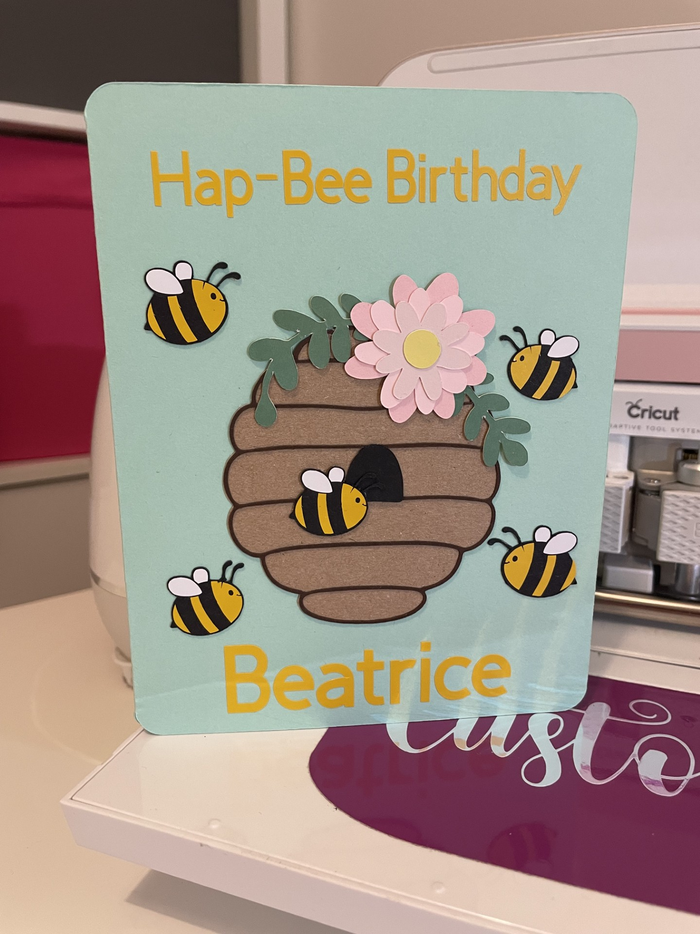 Birthday card with a beehive, bees, and flower, reading "Hap-Bee Birthday Beatrice."