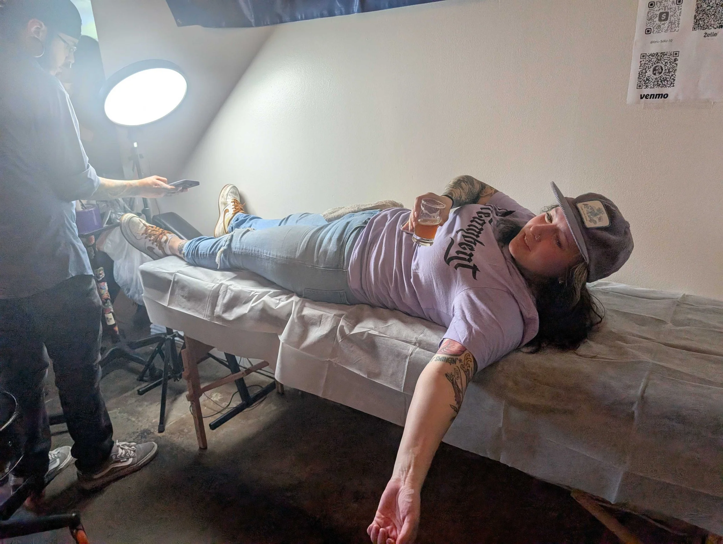 Tattoo artist working on client during live popup at Denver brewery and café event