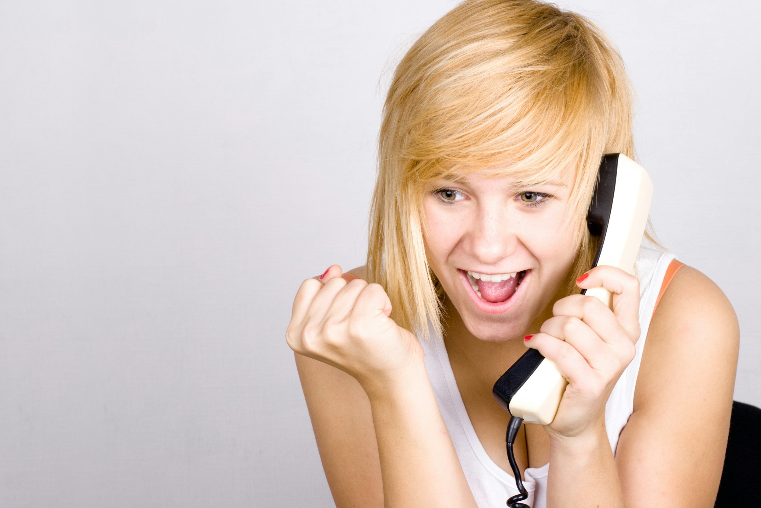 Blond woman excited on a phone call
