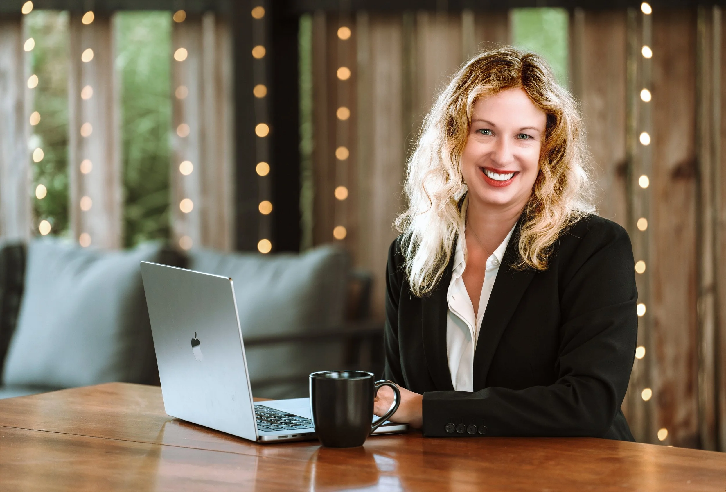 Allison Welch, grant writing trainer, working at a laptop at a wooden table.