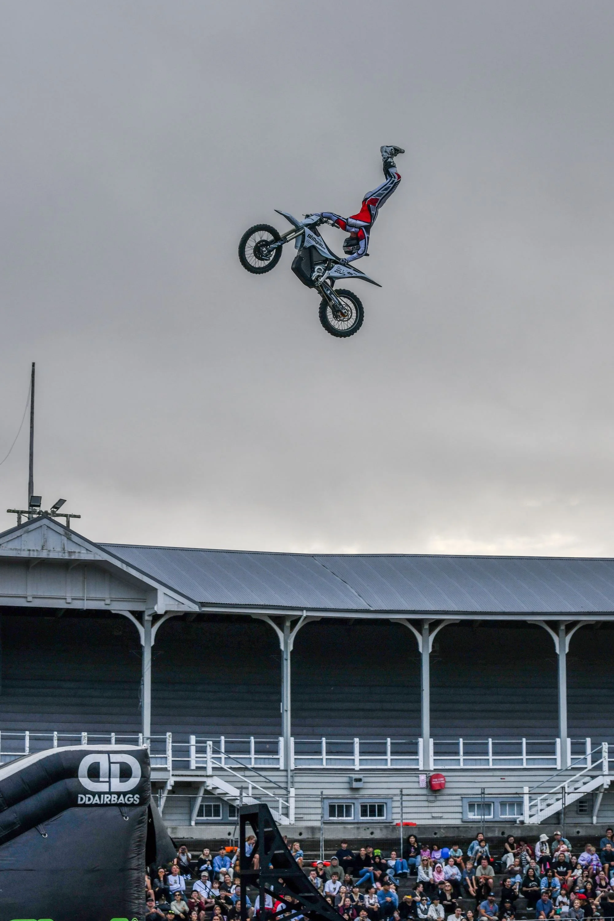 Freestyle motocross rider performing live in front of a crowd at FMX Legends Live event in New Zealand