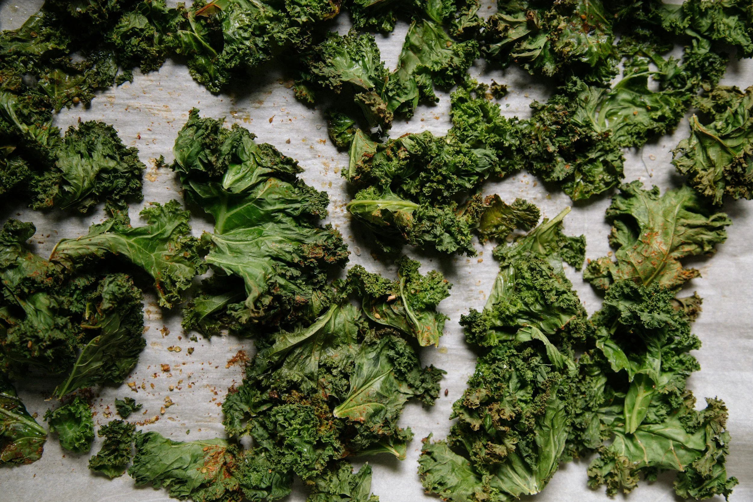 Crispy roasted kale chips on a baking sheet