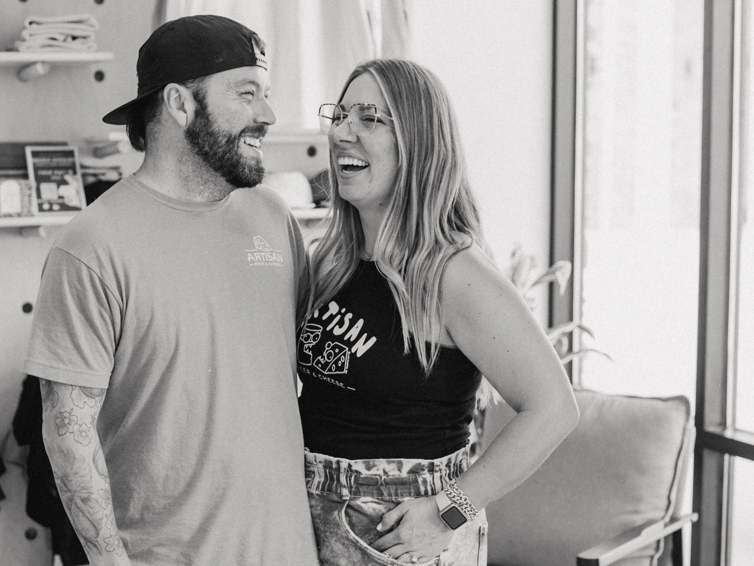 a black and white photo of brian and chelsea jenzer smiling and laughing