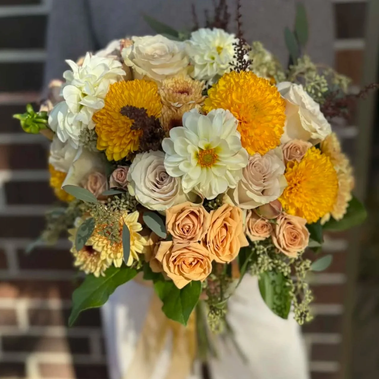 Good Services offering wedding and event florals in Des Moines Iowa bouquet of yellow flowers with dahlias and greenery.