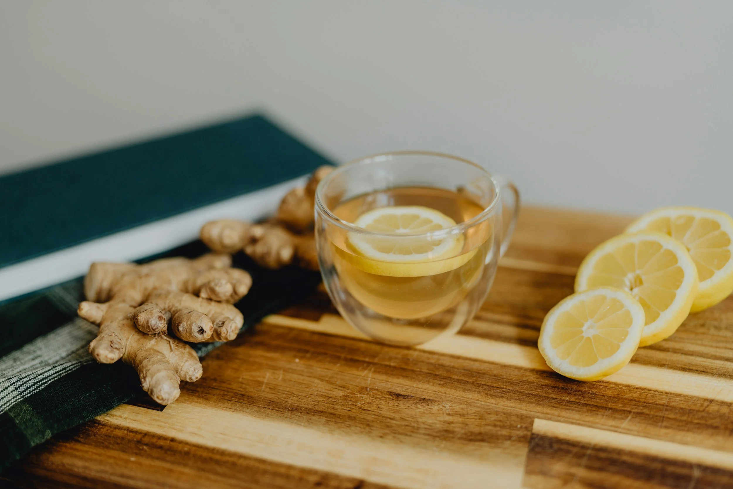 Fresh lemon slices and ginger on a wooden board, highlighting immune-boosting ingredients in The Health PR drip.