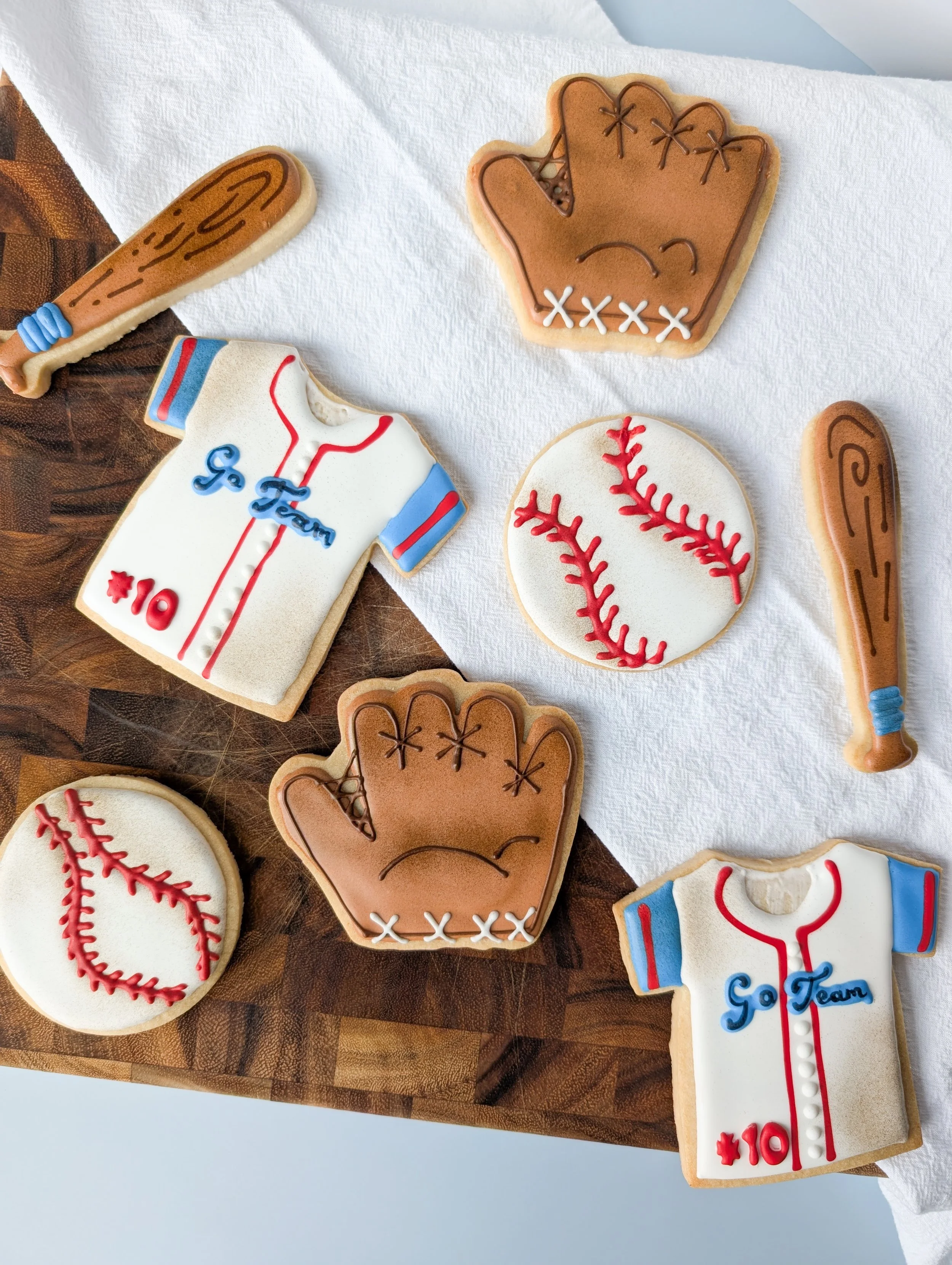 Cookies decorated with baseball and sports themes, including baseball gloves, baseballs, bats, and team jerseys.