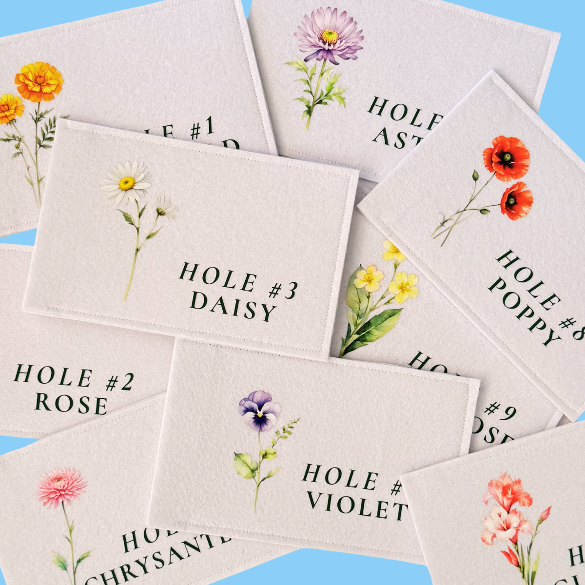 Three white flags on wooden poles against a blue sky, each with a green number: 1, 2, and 3, arranged from left to right.