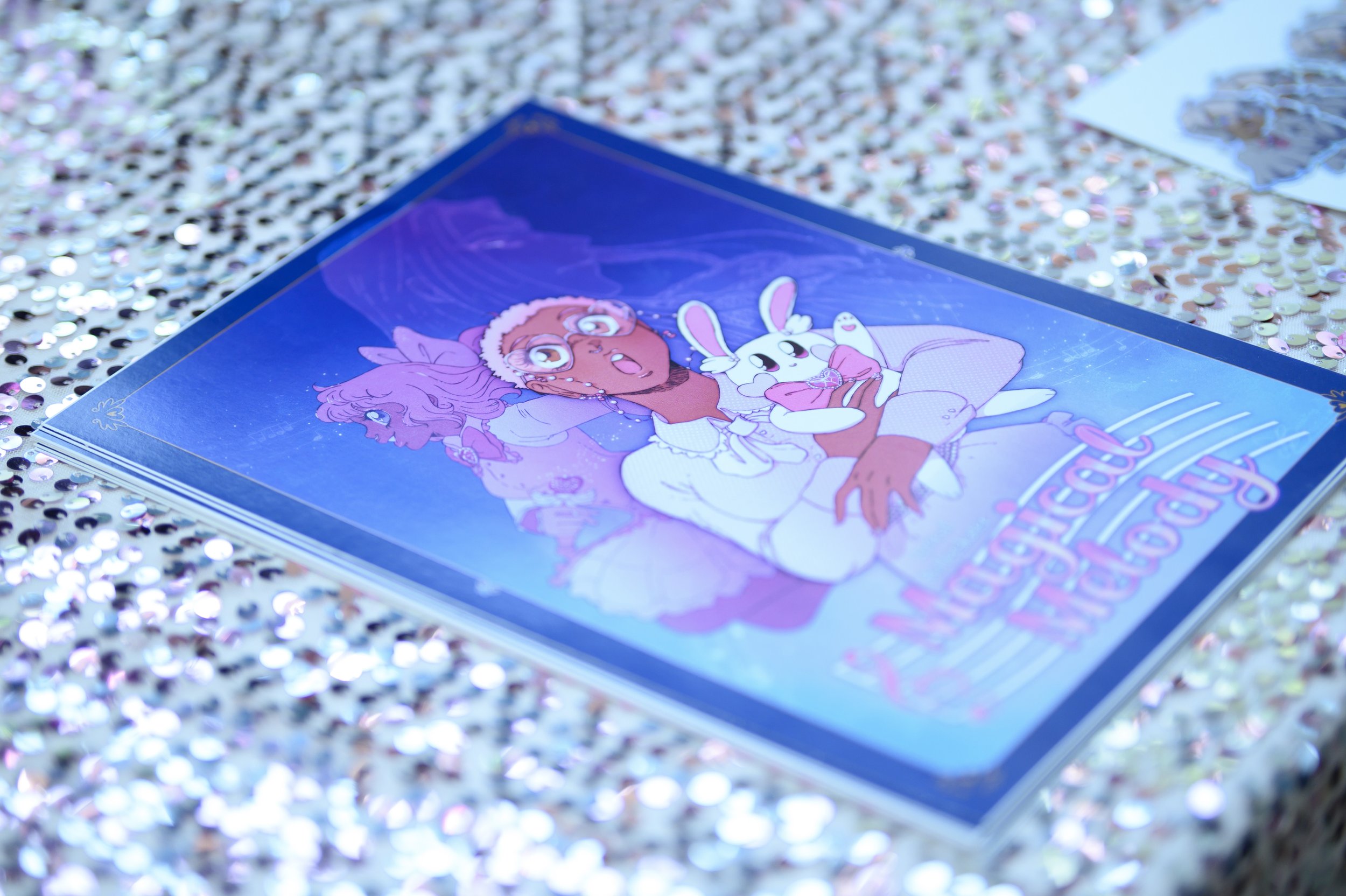 A colorful illustrated book cover on a glittery surface, featuring a girl with big eyes and curly hair, holding a white bunny dressed in pink. The title appears to be in pink and purple text.
