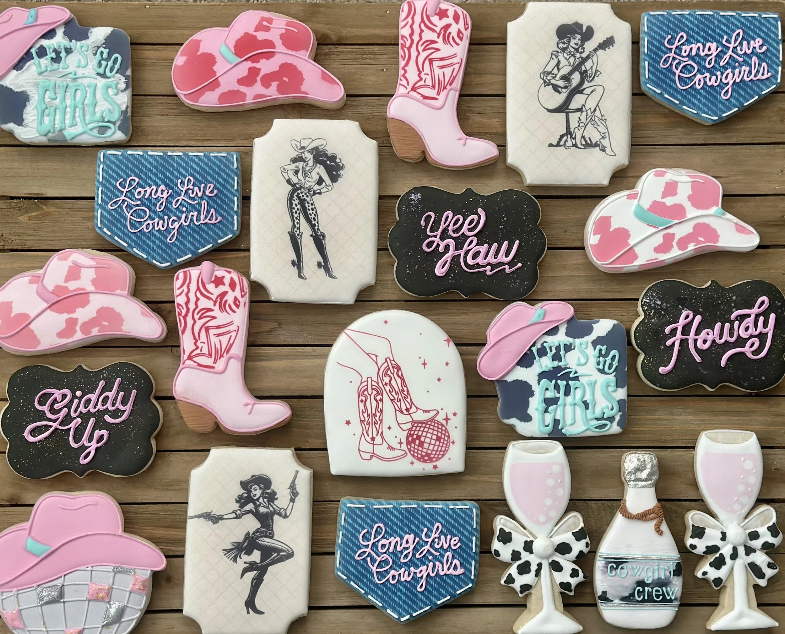Collection of decorated cookies with cowgirl and rodeo themes, including cowboy hats, cowboy boots, western women, beer glasses, and phrases like 'Let's go girls', 'Long Live Cowgirls', 'Giddy Up', 'Yee Haw', and 'Howday'.