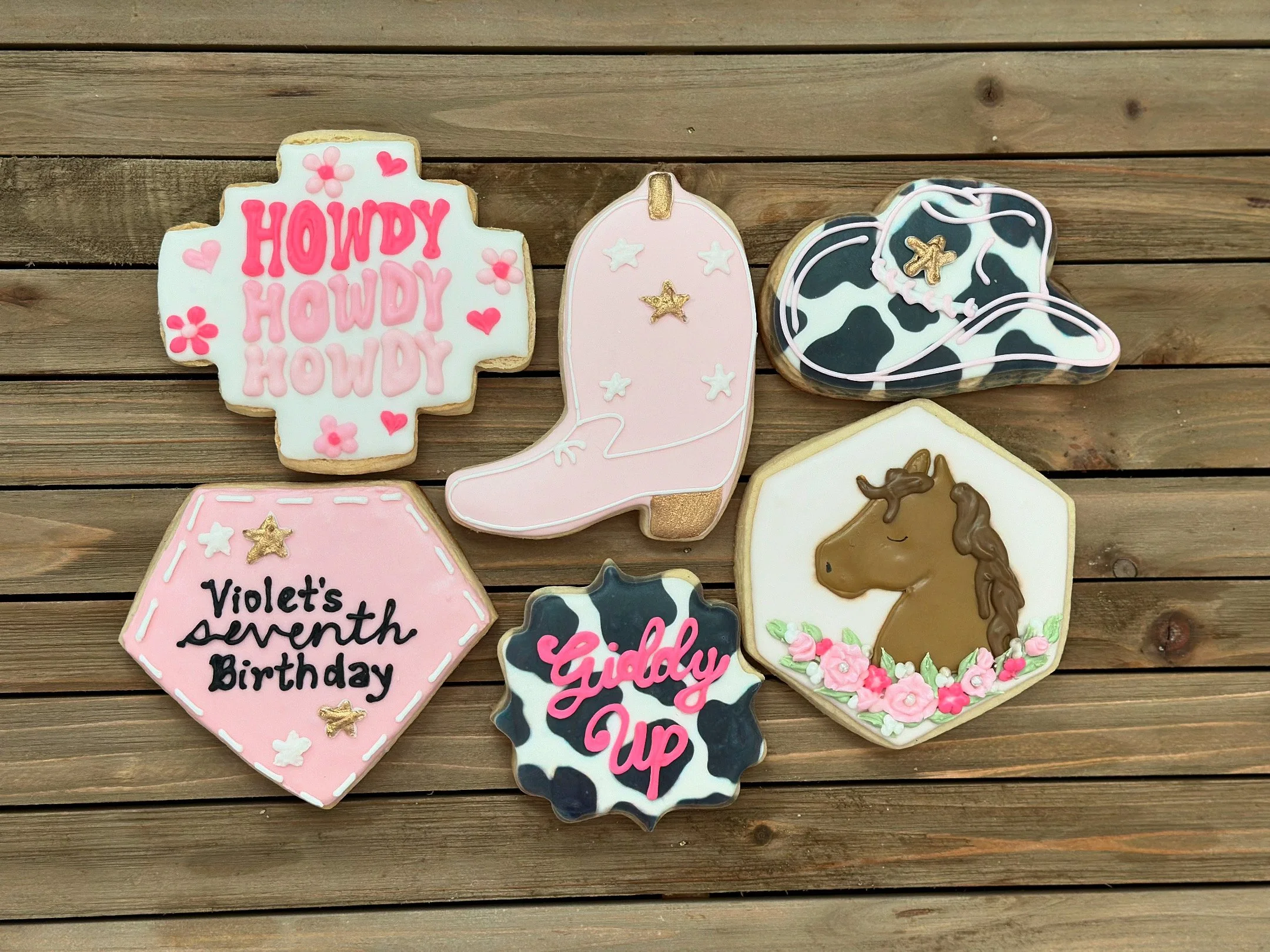 Collection of decorated cookies on a wooden surface. The cookies include one with