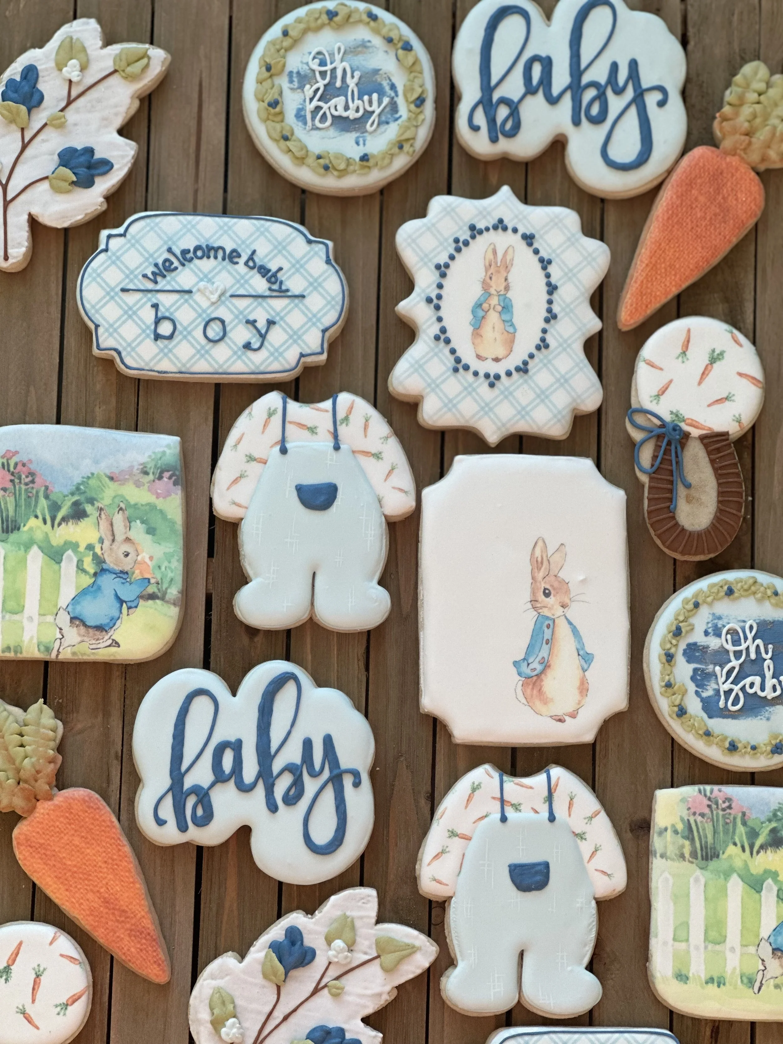 Assorted baby-themed cookies with illustrations of rabbits, carrots, and text such as "baby" and "welcome baby."