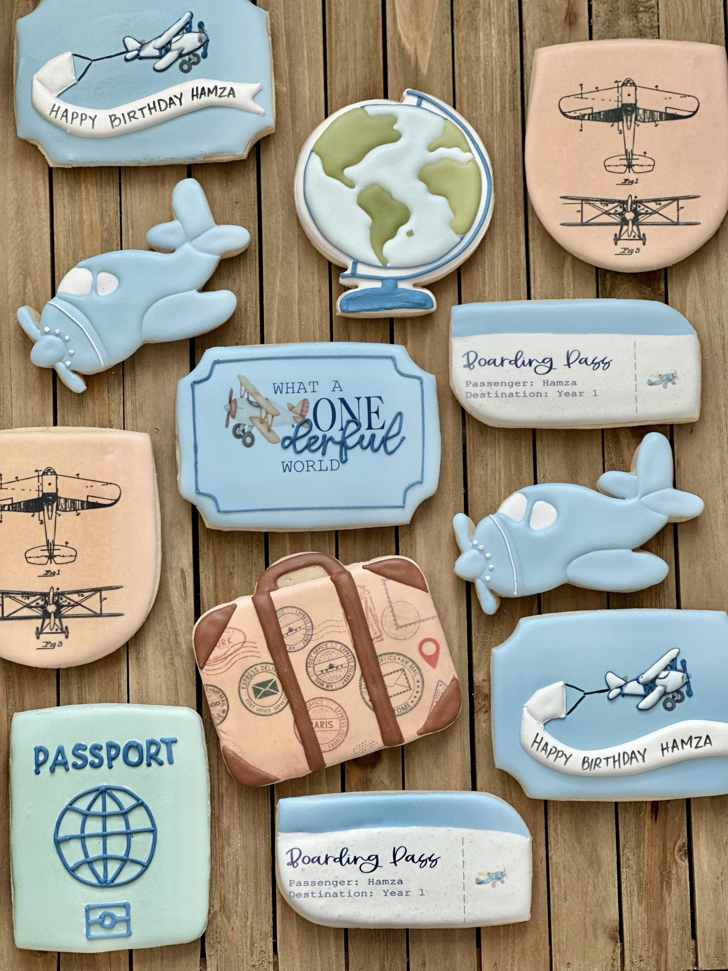 Decorative cookies with travel and airplane themes, including a globe, boarding passes, a passport, and airplane illustrations.