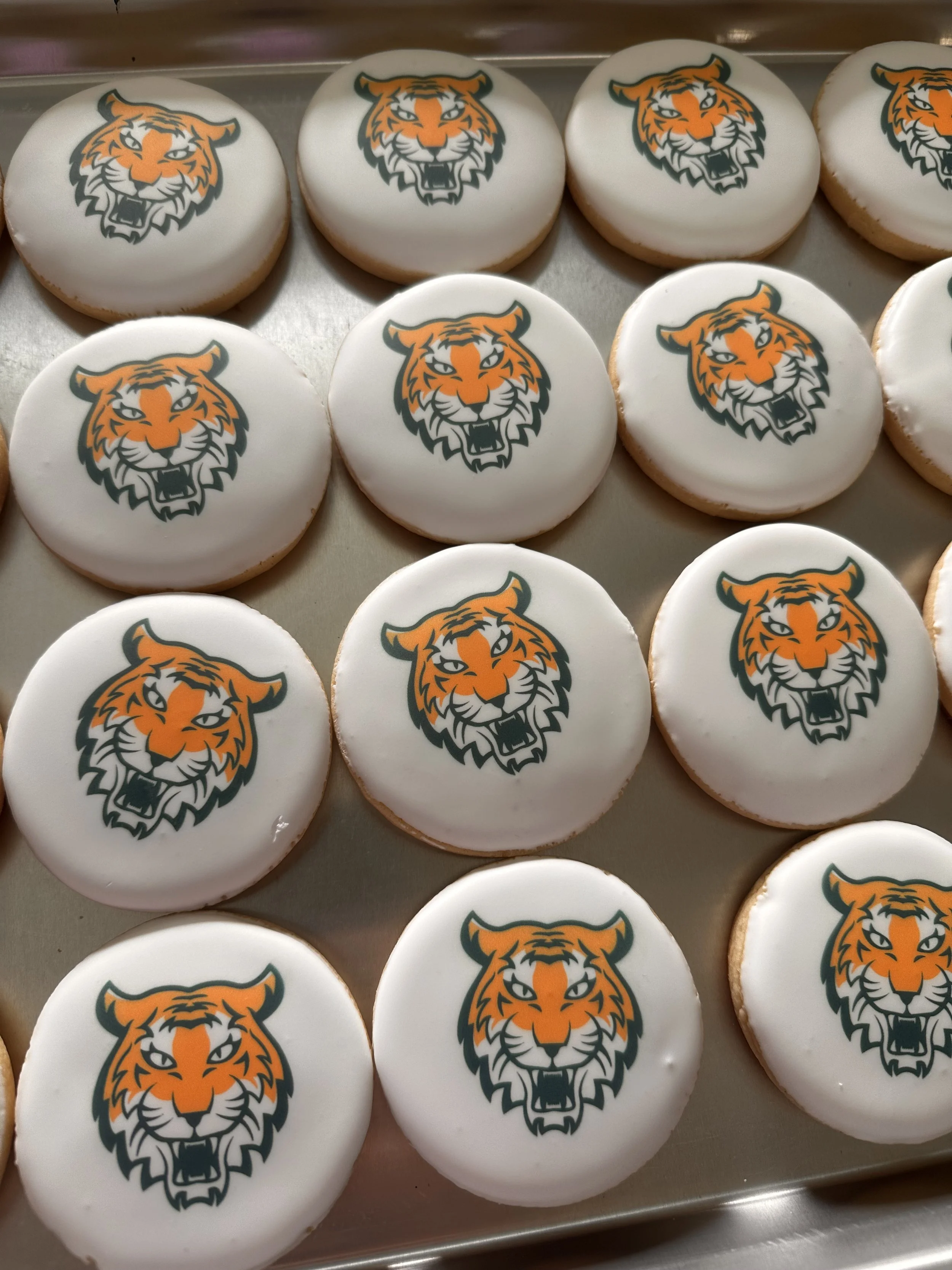 Cookies with a tiger logo printed on white icing.