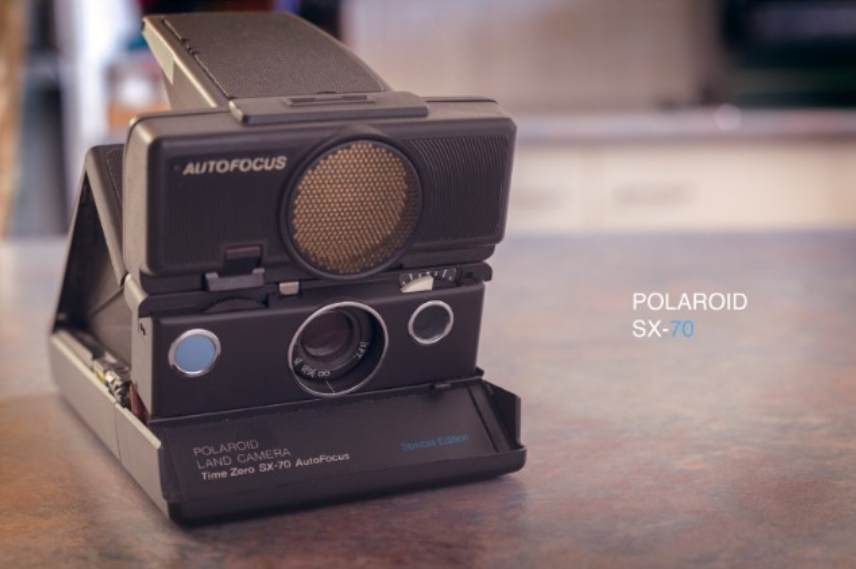 Polaroid Land Camera Time Zero SX-70 AutoFocus on a table with a blurred background.