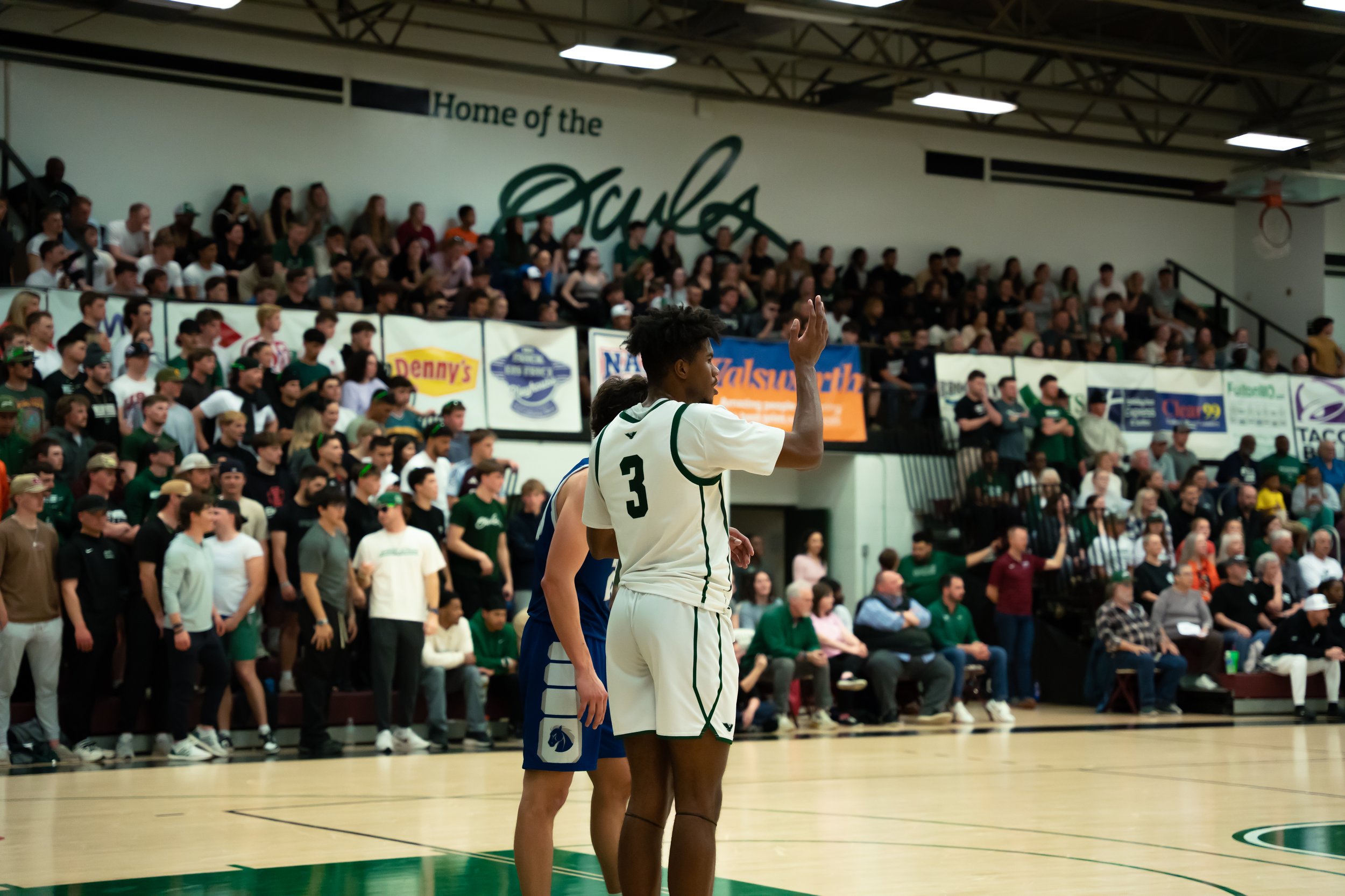Basketball game with players and spectators in the gymnasium.