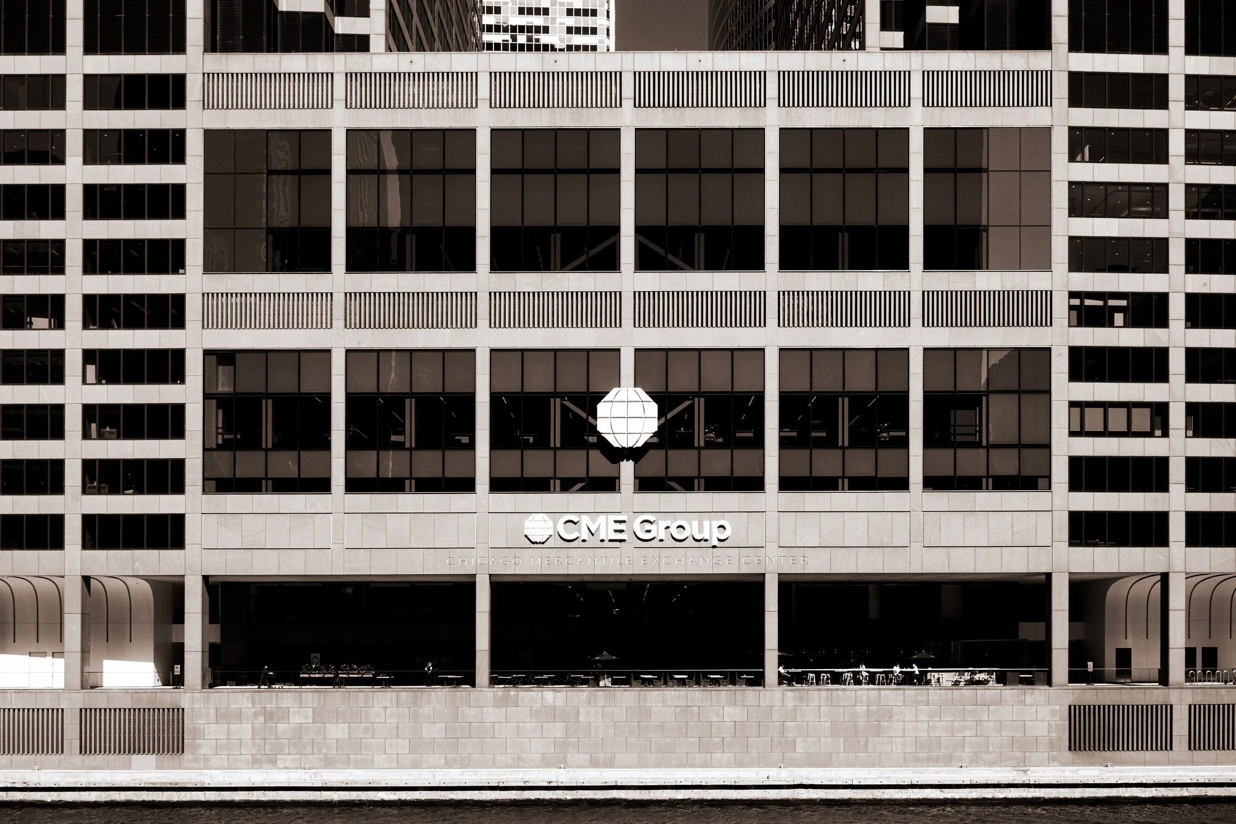 The exterior of a modern office building with a sign for CME Group at Chicago Mercantile Exchange Center.