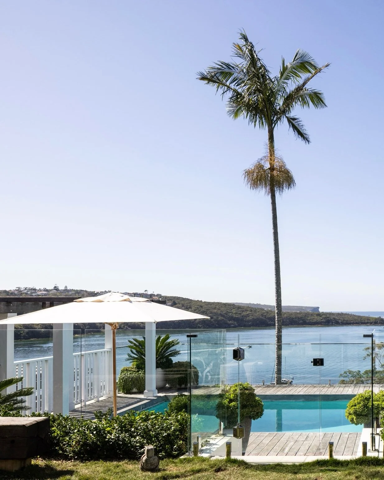 Framed by uninterrupted water views, the lower living level at our Chinaman&rsquo;s Beach, Mosman project opens to a generous lawn and fire pit, leading to the pool and cabana to create a seamless indoor to outdoor connection. House, pool and landsca