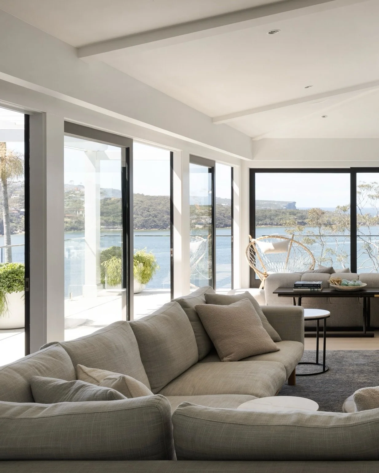 A light-filled living space, designed to make the most of the home&rsquo;s stunning water outlook. Carefully defined zones invite relaxation, from the warmth of the stone fireplace, to a dedicated spot for watching the ever changing waterfront, to a 