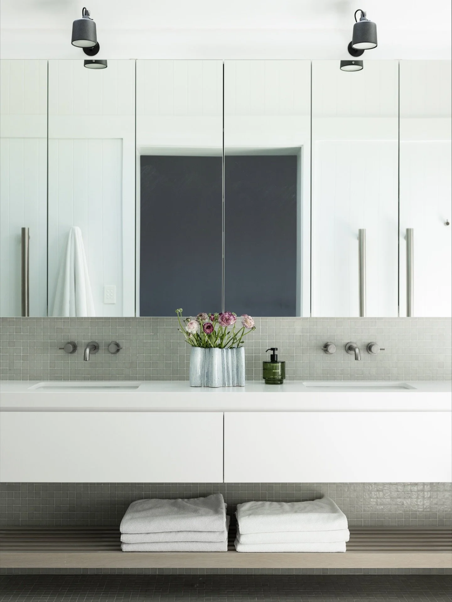A cool, calm palette for the ensuite at our Chinaman&rsquo;s Beach, Mosman project. Opaque glass mosaics reflect natural light from the overhead skylights, while bespoke limed oak shelving adds a soft, organic contrast. Project @strittdesignandconstr