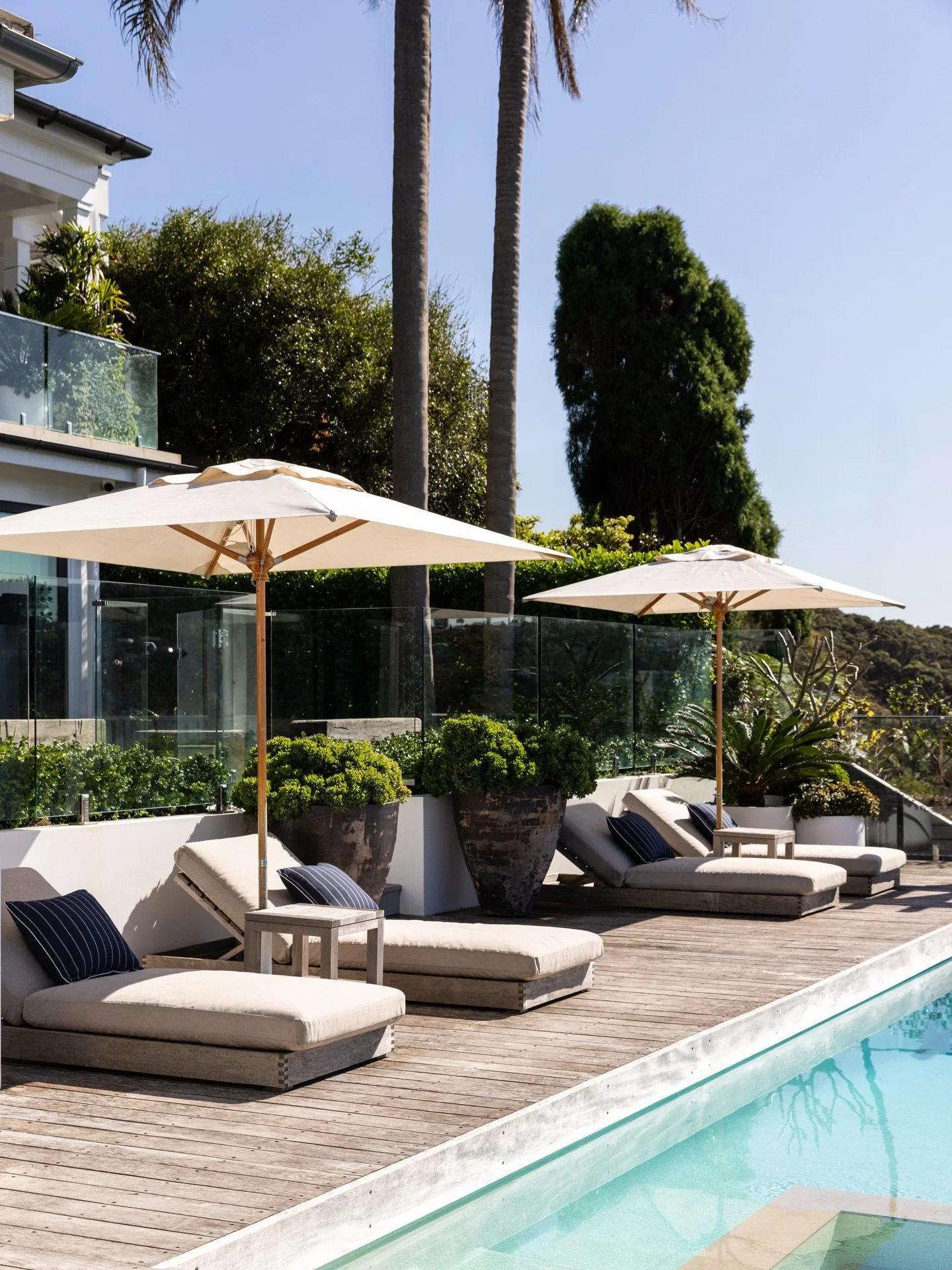 Sun loungers, umbrellas and a pool deck designed to gracefully weather to silver-grey over time invites you to relax and unwind. Happy long weekend! Project @strittdesignandconstruction. Photography @simonwhitbreadphoto. #chinamansbeachhouse #strittd