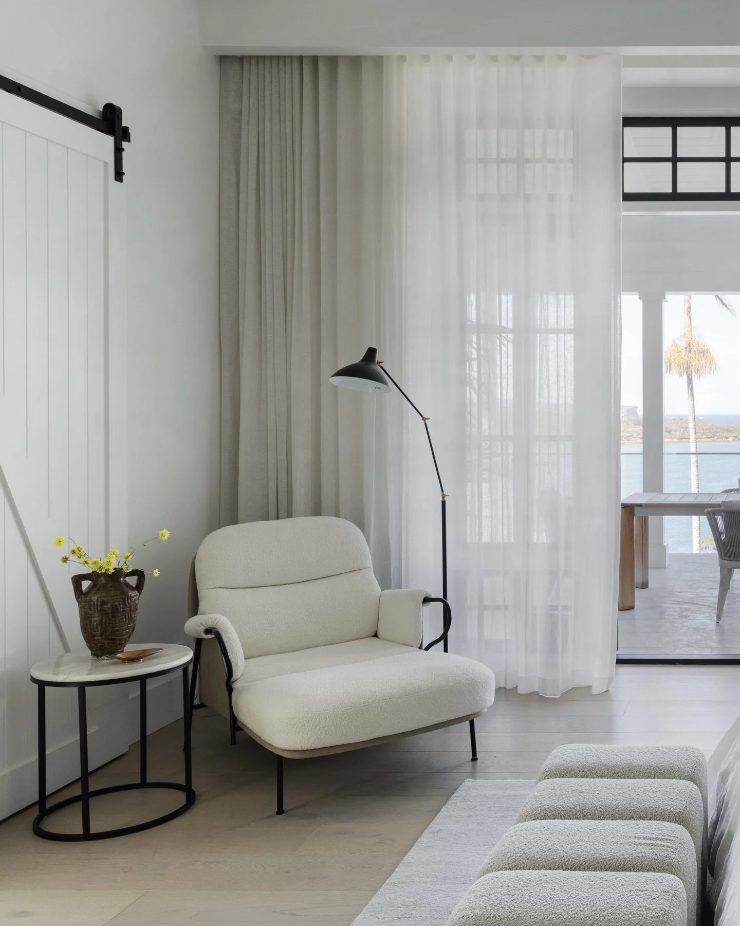 Softly layered, this serene bedroom opens to an expansive verandah and calm water views beyond. Beautifully furnished by our clients. Project @strittdesignandconstruction. Photography @simonwhitbreadphoto. Styling @olgalewisstyling for @homebeautiful