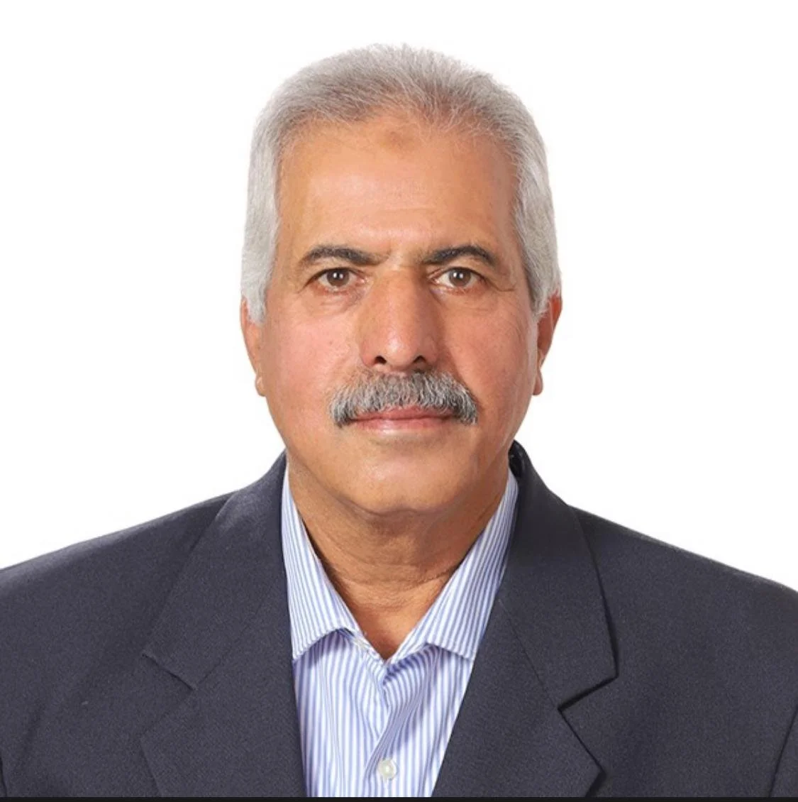 A middle-aged man with gray hair and a mustache wearing a dark suit and striped collared shirt, looking directly at the camera against a white background.