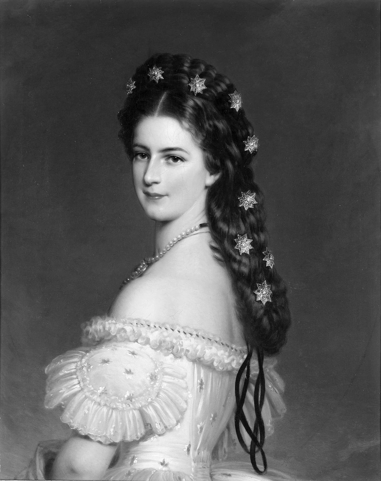 A black-and-white portrait of a woman with long dark hair adorned with star-shaped accessories, wearing a pearl necklace and a detailed dress with puffed sleeves.