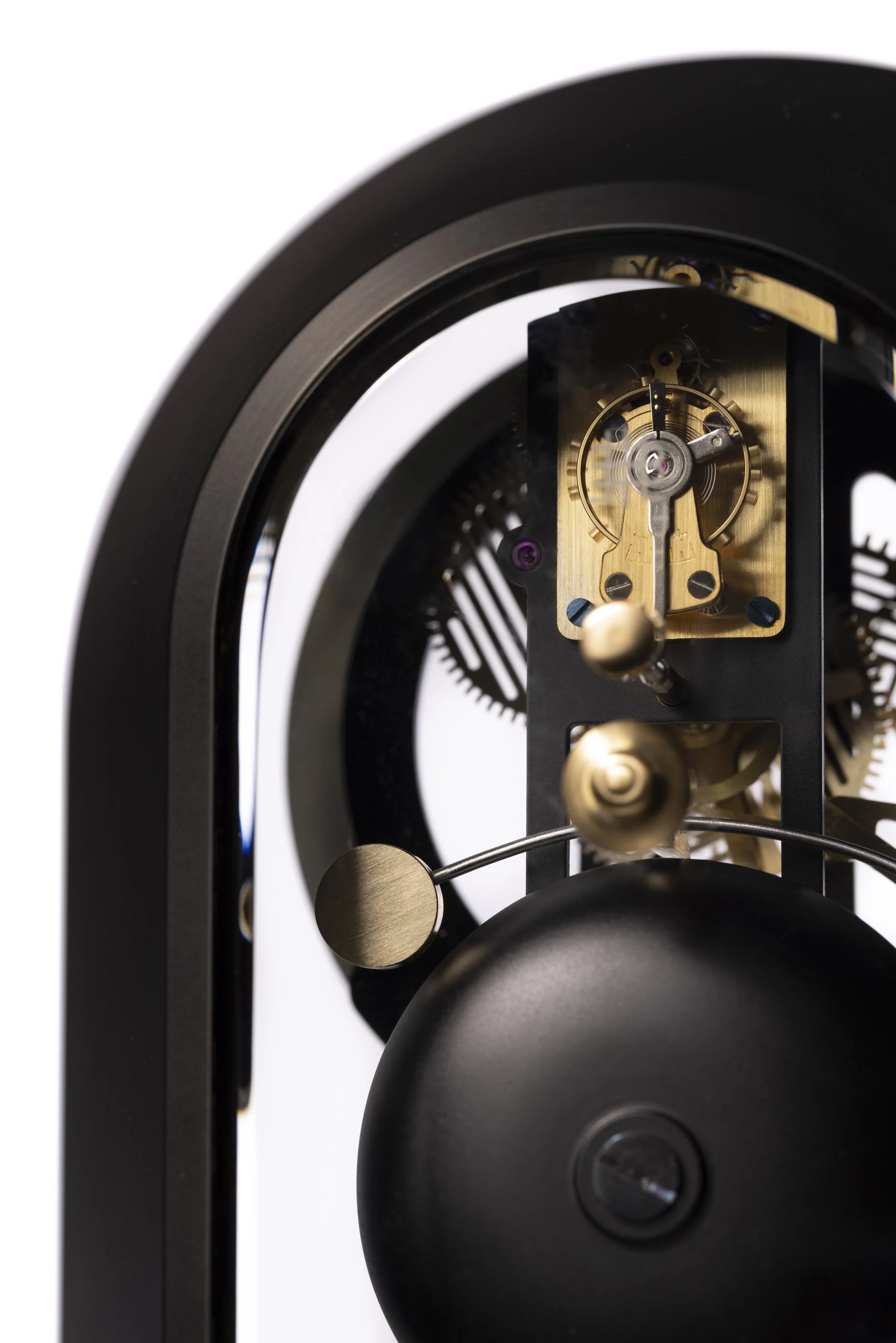 Close-up of the internal mechanical components of a clock, showing gears, a balance wheel, and a pendulum, with a black frame surrounding the parts.