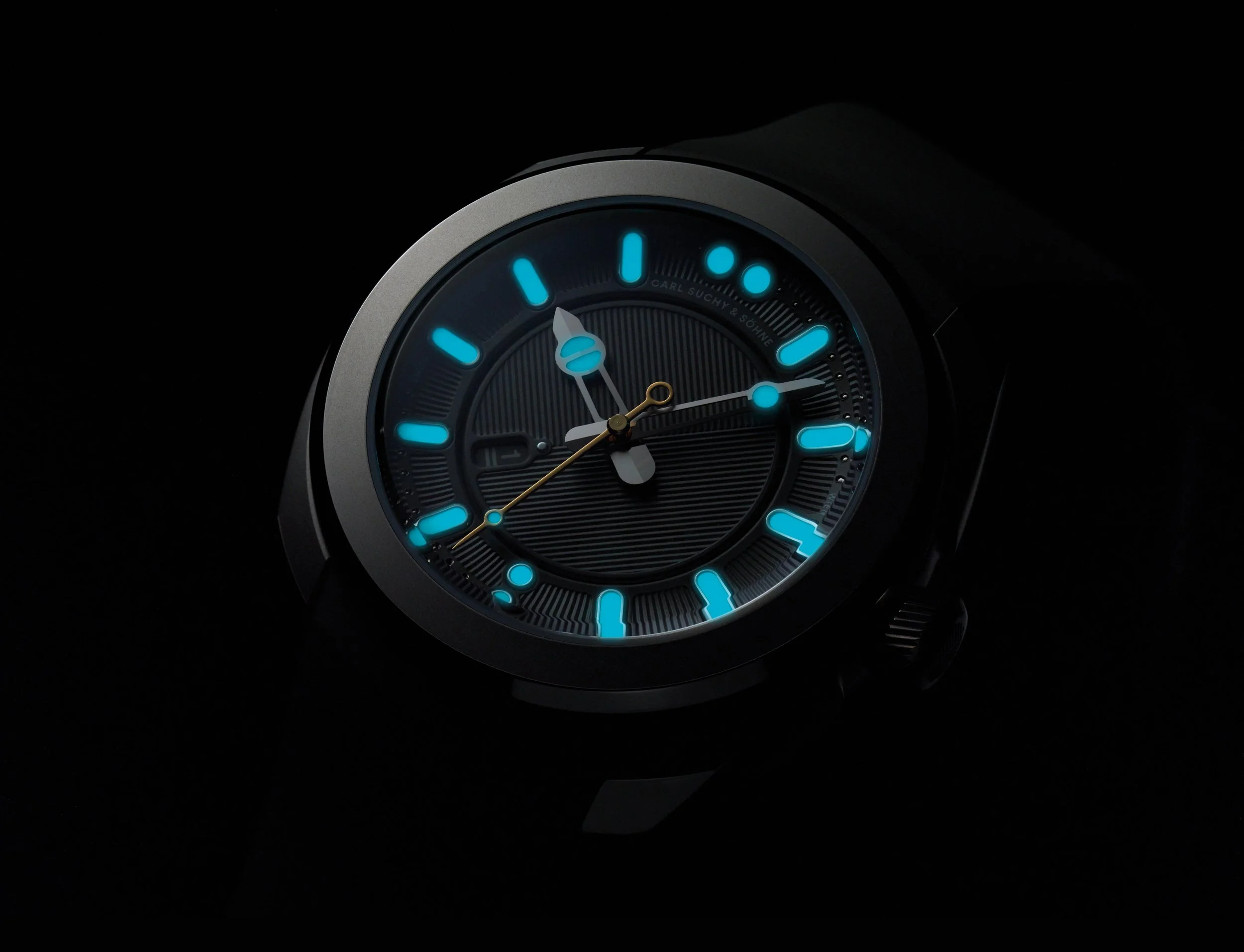 A close-up of a wristwatch with a black dial, glowing blue hour markers, and luminous hands, set against a dark background.