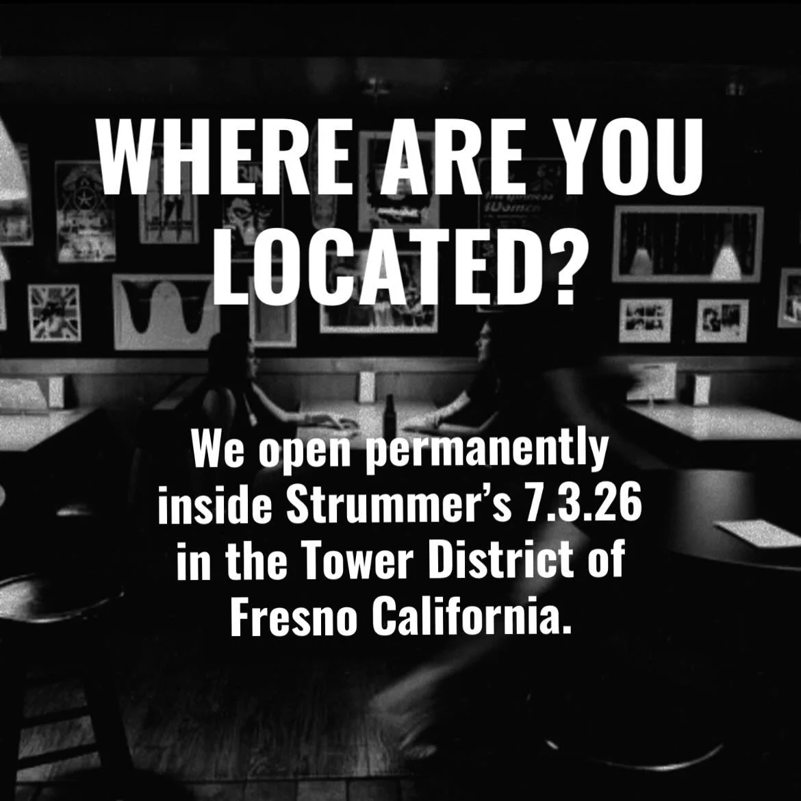 Sign with text overlaying a dimly lit interior space, showing two people sitting at a table with artwork hanging on the wall behind them. The sign reads: 'WHERE ARE YOU LOCATED? We open permanently inside Strummer's 7.3.26 in the Tower District of Fresno California.'