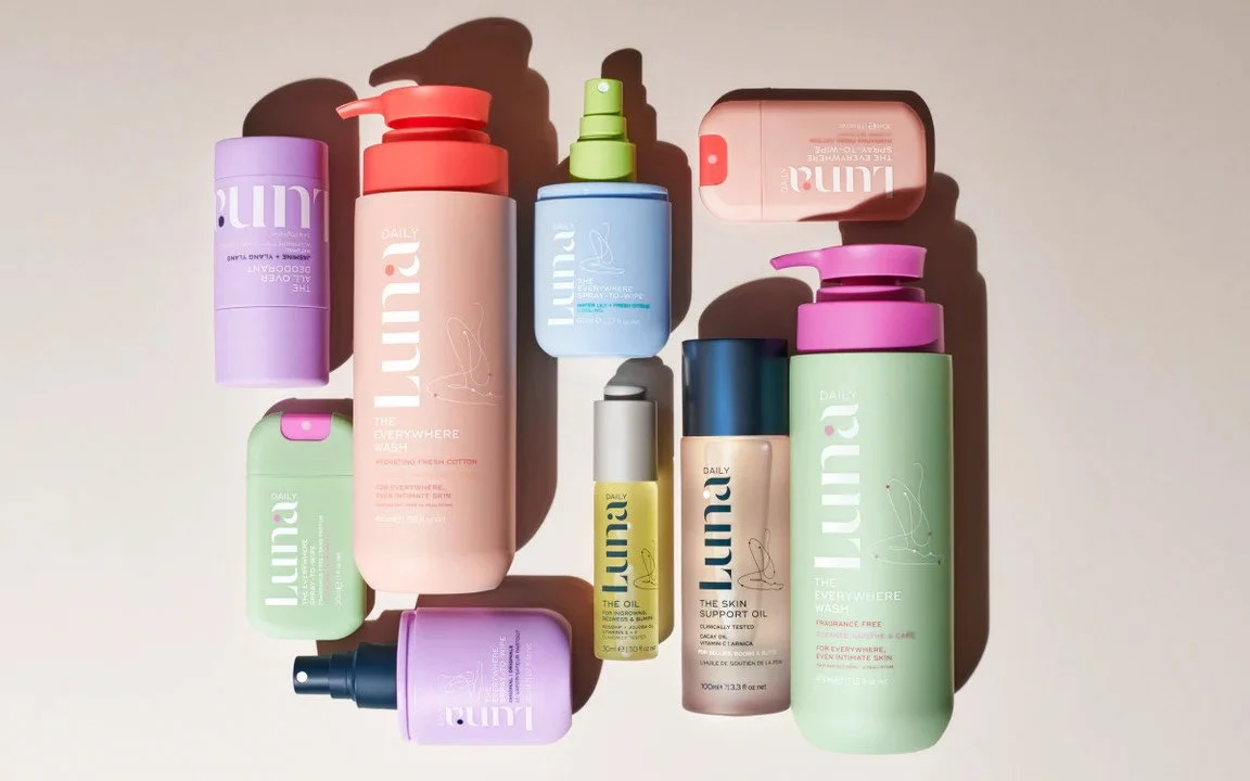 Collection of colorful skincare bottles and containers arranged on a light surface.