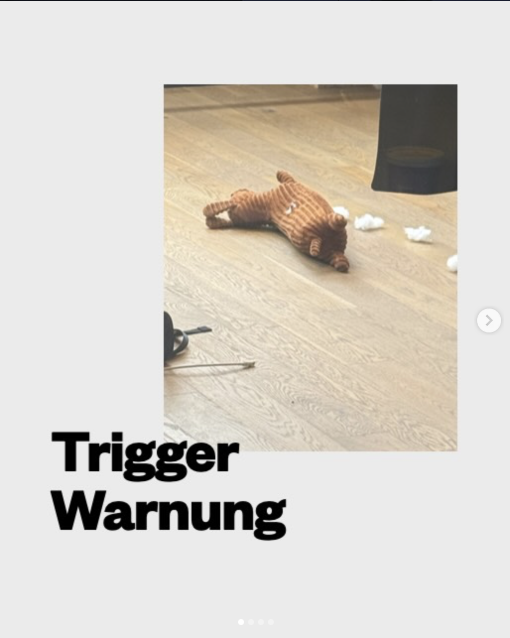 Ein Spielzeug-Hund liegt umgestürzt auf einem Holzboden, umgeben von zerstreuten Wattebällen.