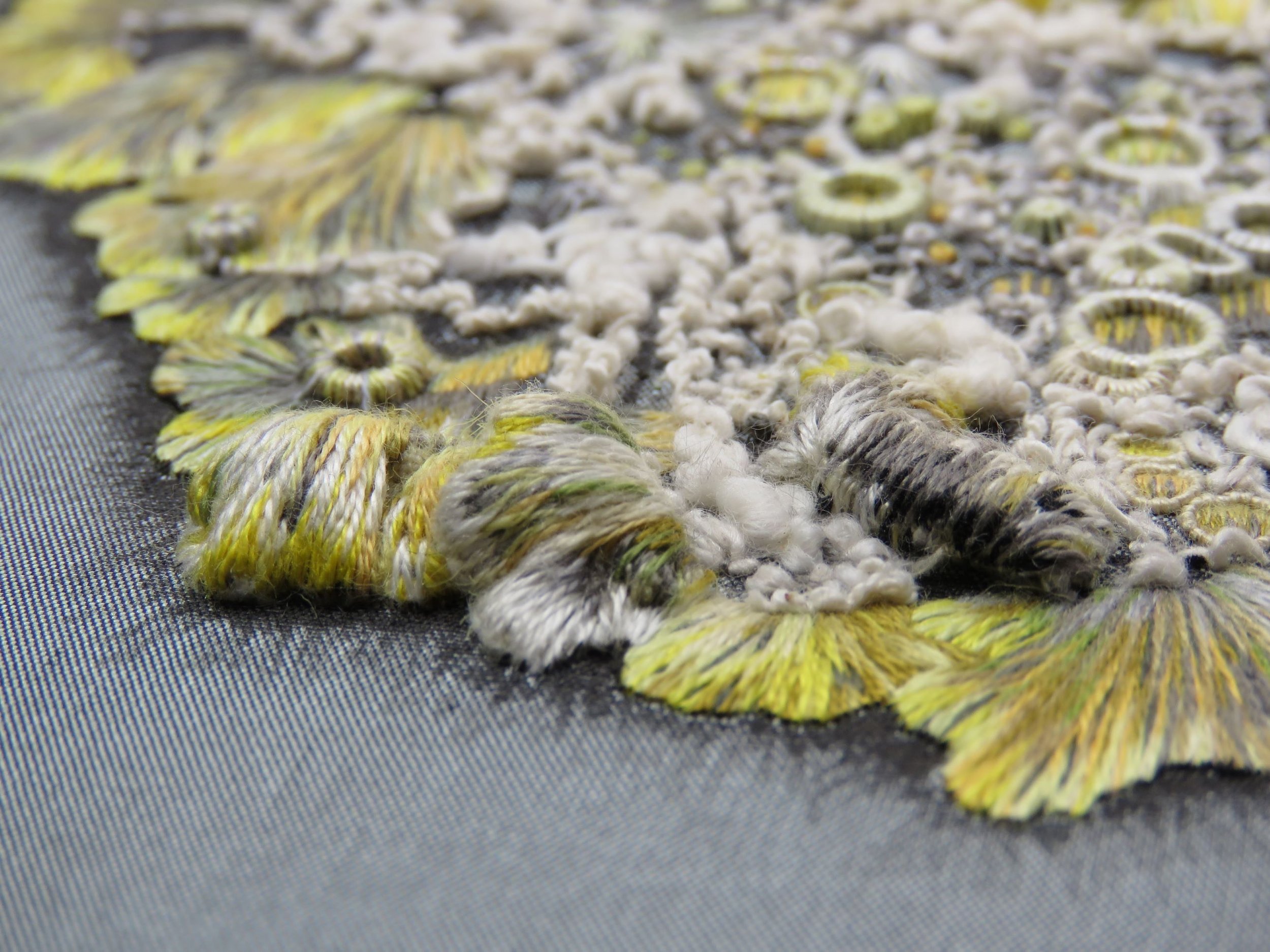 This is a close up of an embroidery that was accepted and subsequently sold at The Broderers Embroidery exhibition in 2025. It is a mixed media embroidery piece and is a part of a lichen that I photographed in St James's Park, London. 