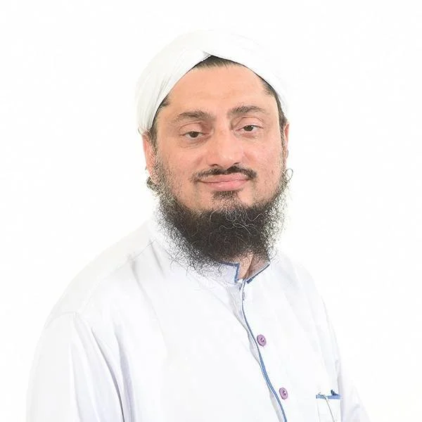 Portrait of a man wearing a white turban and traditional white clothing with blue accents, with a beard, standing against a white background.