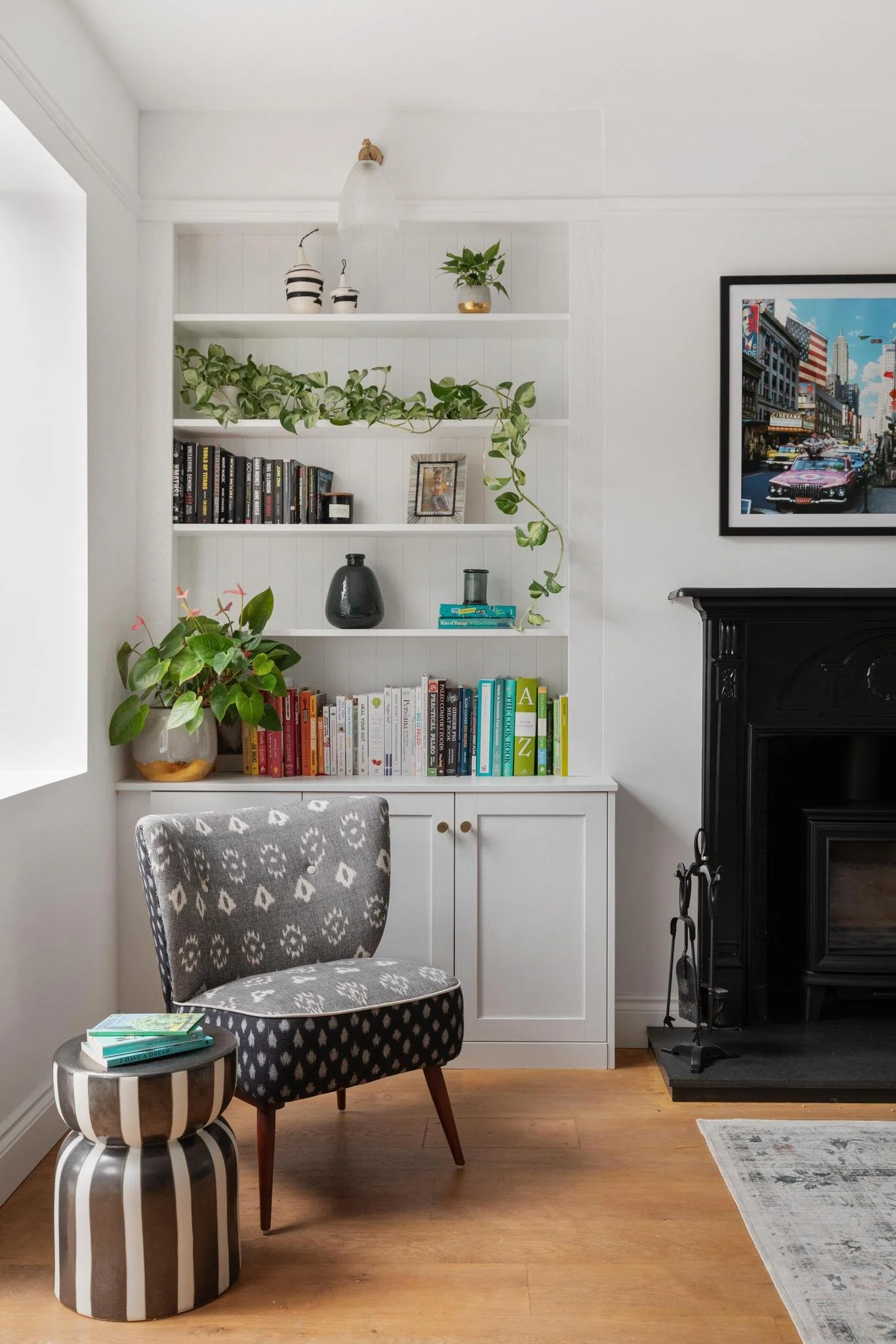 Reading corner with bespoke built-in shelving and a black fireplace - designed by Studio Brook for an Edwardian family home in East Sheen village, UK.