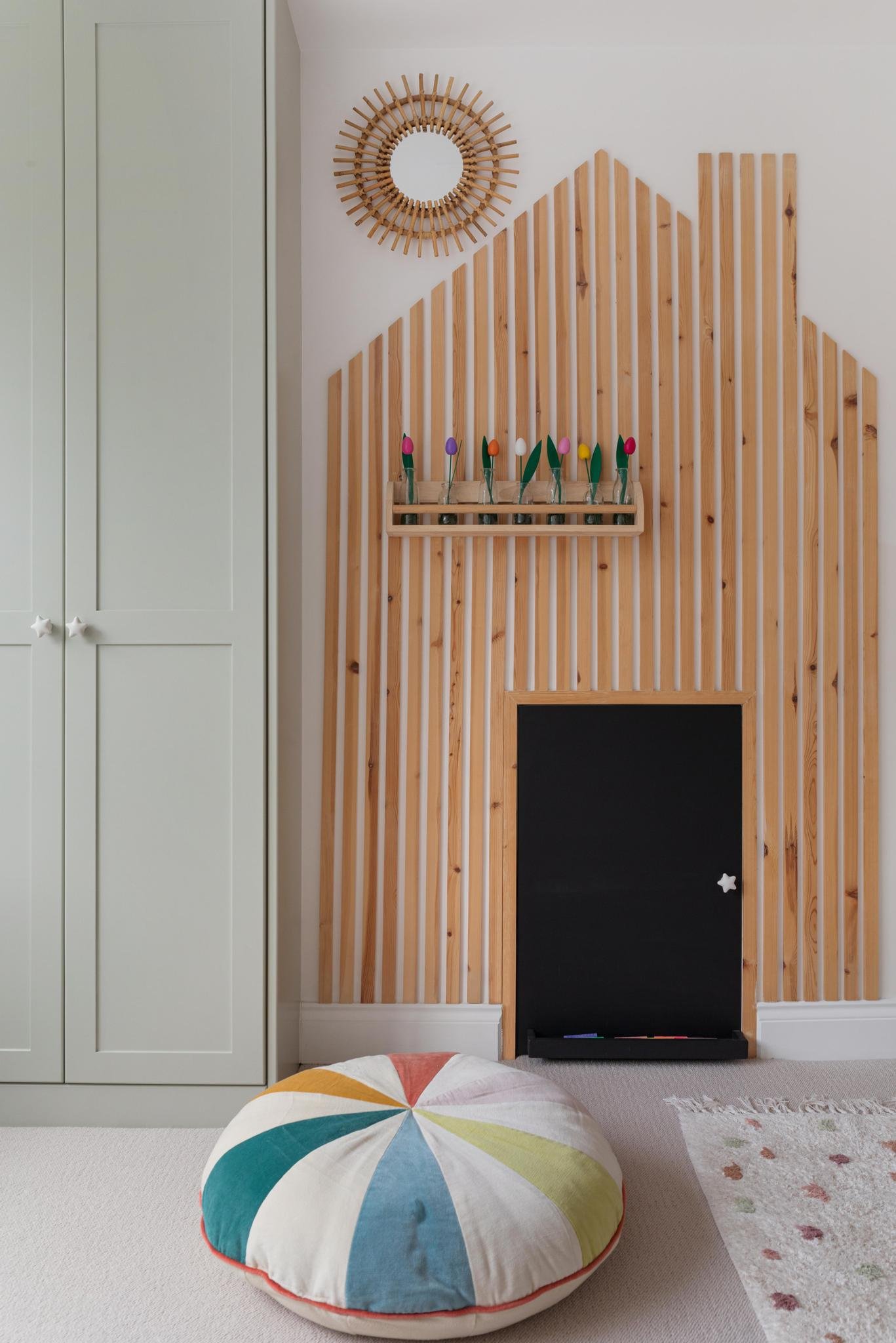 Playful child's bedroom with pastel green wardrobes and wooden playhouse feature with chalkboard door to hidden cupboard - designed by Studio Brook for an Edwardian family home in Richmond, UK.