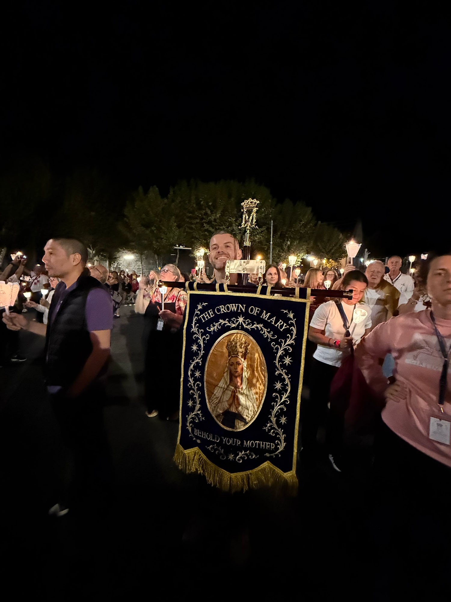 Kyle holding the COM flag in the procession at night.jpg